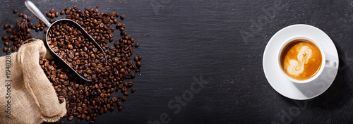 cup of coffee and coffee beans in a sack, top view