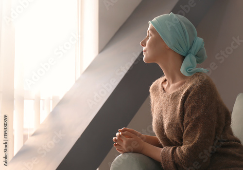Young woman with cancer in headscarf indoors © Africa Studio