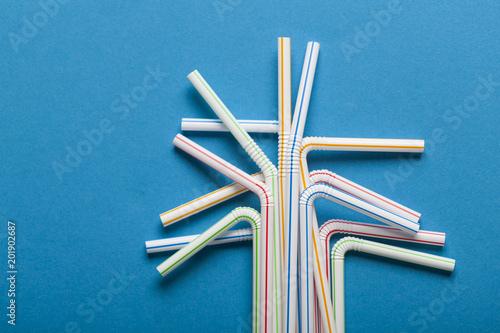 Plastic straws on a blue background © ink drop