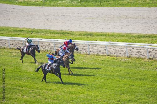Galloping Race Horses And Jockeys In Racing Competition