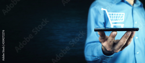Businessman holding a phone with a shopping icon. Online shopping © andranik123