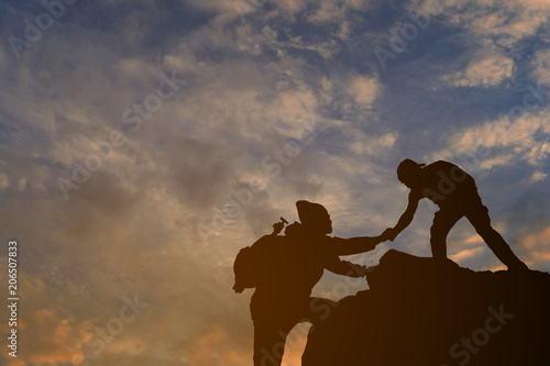 friends helping each other and with teamwork trying to reach the top of the mountains