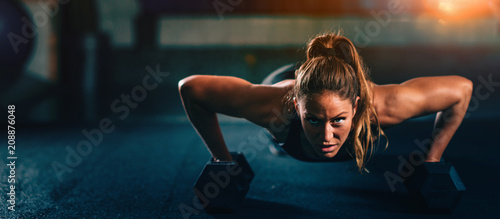 Cross training. Young woman exercising at the gym © Microgen