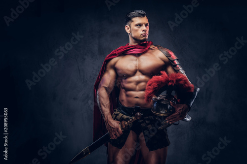 Brutal ancient Greece warrior with a muscular body in battle uniforms