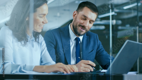 Female Accountant and Male Businessman Sitting at the Desk Having Discussion and Working on a Desktop Computer, Solving Problems. Modern Stylish Office with Beautiful People.