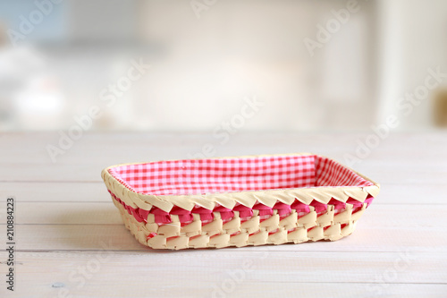 Straw basket at kitchen table empty space. © nys
