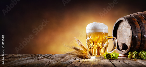 Beer Mug With Wheat And Hops In Cellar With Barrel