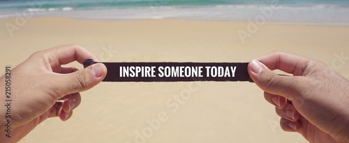 Motivational and inspirational quote - ‘Inspire someone today’ written on a piece of paper. With vintage styled background.