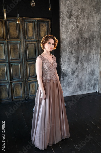 A brunette girl in a beautiful dress posing for a photographer © FEDORENKO