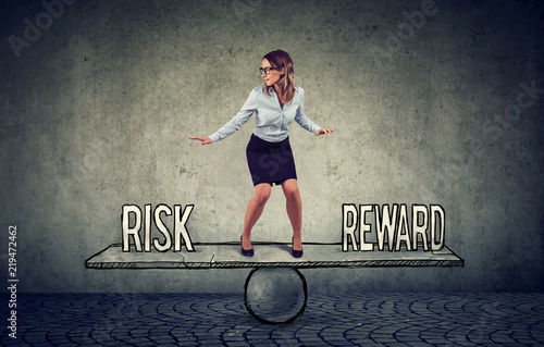 Skillful young business woman balancing between reward and risk