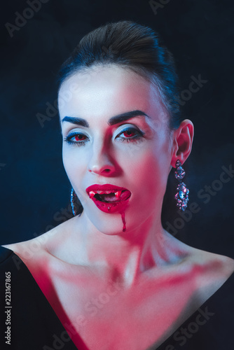Sexy Vampire Woman Licking Her Lips On Dark Background Sexy Vampire Woman Licking Her Lips On Dark Background