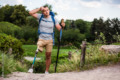 Tired young man with prosthesis trying Nordic walking © shevchukandrey