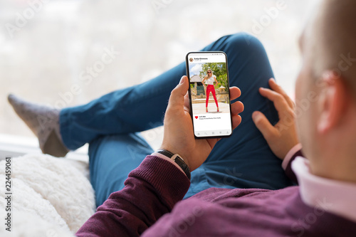 Man looking at photo sharing app on mobile phone