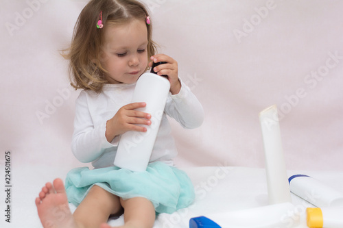 Beautiful Baby Holding A Bottle In The Hand With Shower Gel Beside