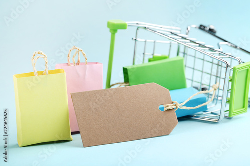 Small paper shopping bags with shopping cart on blue background