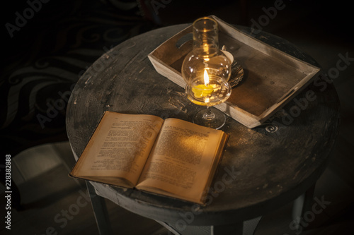 open book under the lamp with a candle © srki66