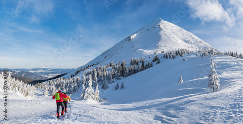 Winter hiking. Tourists are hiking in the snow-covered mountains. © volff
