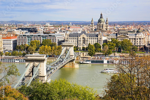 Chain Bridge or Szechenyi Bridge across Danube river in Budapest, Hungary, with old buildings and dome of St Stephen's Basilica or Szent Istvan Bazilika, in autumn. © Brigida Soriano
