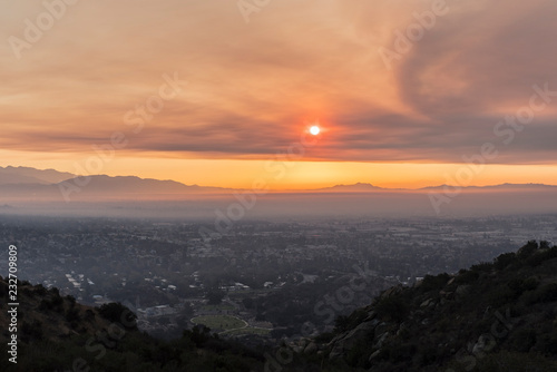 Los Angeles, California, USA - November 10, 2018: Smoke filled sunrise sky above the San Fernando Valley. Smoke is from the Woolsey fire in Malibu and Ventura County. © trekandphoto