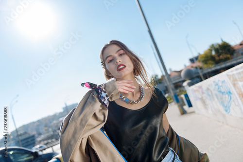 Trendy skinny fashion blogger wearing beige coat with accessories © Viacheslav Iakobchuk