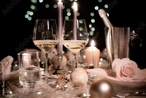 christmas eve party table with wine glass and glitter season's greeting decoration