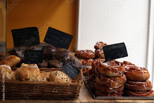 Trays and baskets of freshly baked buns, cakes, cookies, scrolls, sweets and biscuits inside a bakery