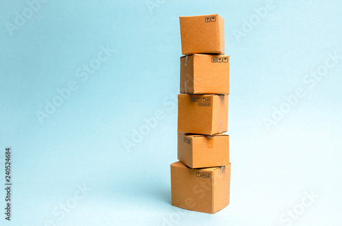 Tower of cardboard boxes on a blue background. The concept of moving and delivery of goods and goods. Commerce and business processes, logistics, distribution and sales.
