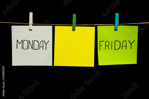 Copy space. Three stickers. Notes is written on extreme sheets. Monday. Friday. Stickers are attached to the rope with clothespins.