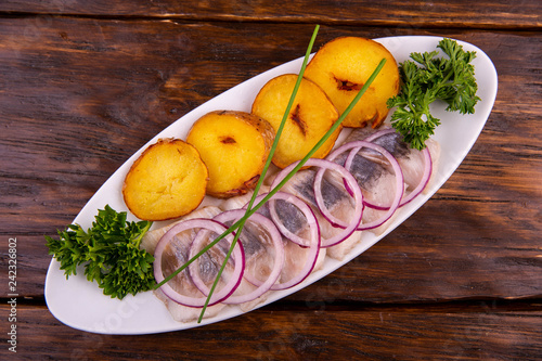 A light-salted herring with potatoes on a grill and fragrant oil © twins03