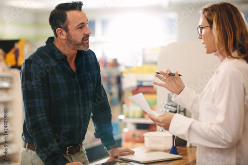 Pharmacist explaining a prescription to customer