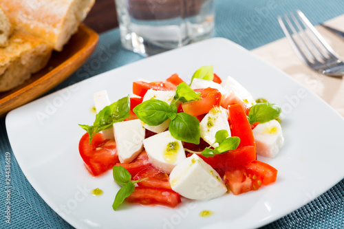 Caprese salad with fresh tomatoes, mozzarella cheese and basilic herb © JackF