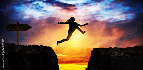 courageous and motivated woman jumps the crevasse