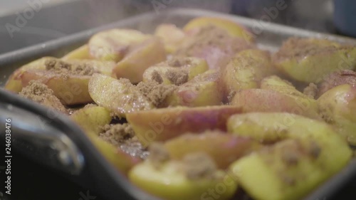 Closeup of peaches cooking with sugar in a frying pan with someone mixing them. © blackboxguild