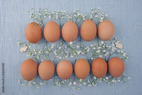  Eggs nature in two rows, in between Gypsophila and Easter bunnies on woven tablecloth © AGM
