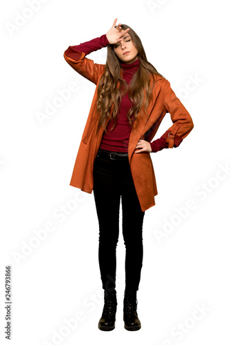 Full-length shot of Young woman with coat with tired and sick expression on isolated white background © luismolinero