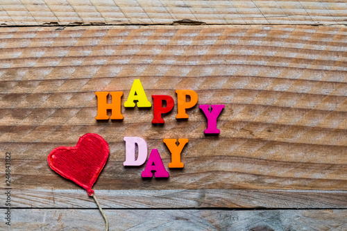 Happy day écrit en lettres bois et coeur rouge sur un fond bois © PicsArt