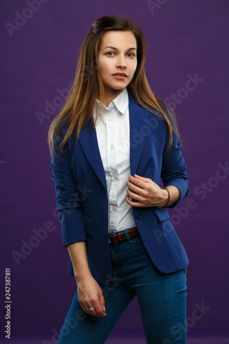 Portrait of a young girl in business suit isolated on a purple background. © ksi