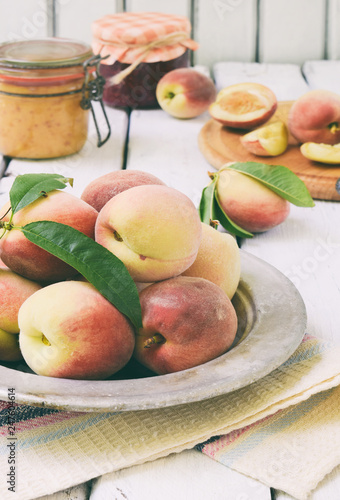 Fresh peaches in metal bowl. Making of jam or confiture from organic fruits and berries on a light background. Copy space. © Oksana_S