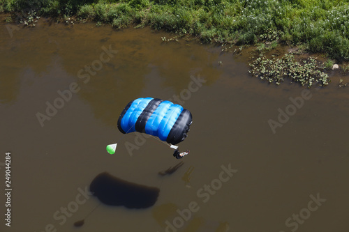 BASE jumper before landing on the water near the river bank. View from above. © esalienko