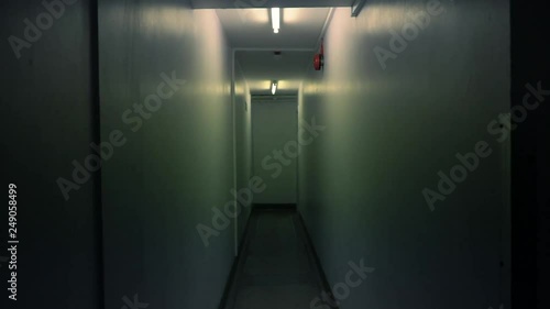 Long, dark corridor, lit with fluorescent tubes. Wide angle shot with corridor centre frame. © blackboxguild