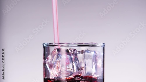Someone drinking cherry or strawberry juice from the glass throw the straw. © Alexandr Steblovskiy
