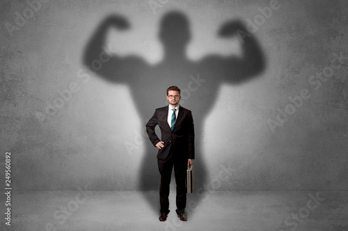 Lovely serious businessman standing with a muscular powerful shadow behind his back © ra2 studio