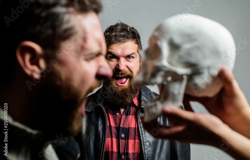 Human fears and courage. Looking deep into eyes of your fear. Man brutal bearded hipster looking at skull symbol of death. Overcome your fears. Be brave. Focused on breaking fear. Psychology concept