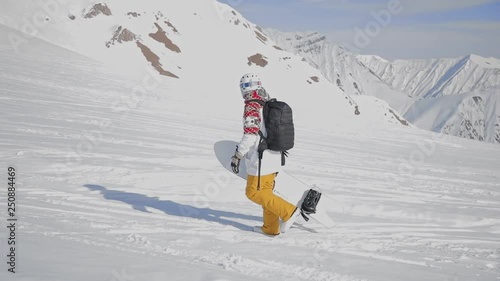 Shot of the man snowboarder holding board on his arms © ADcour