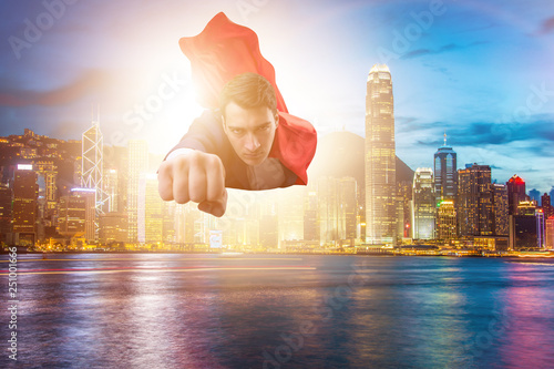 Superhero businessman flying over the city