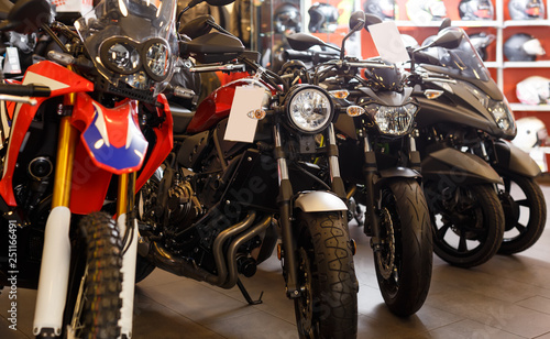 View of range new motorcycles parked in showroom for sale