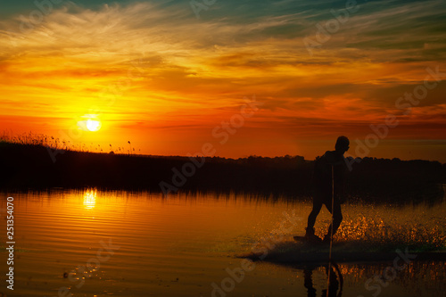 Wakeboarder making tricks on sunset © Shcherbyna