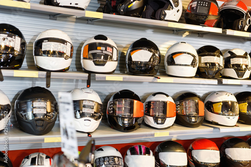 Interior of moto salon with colorful motorcycle helmets on shelves