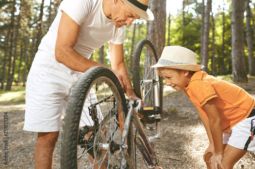 Father and son repair a bicycle in the park. © Studio Romantic
