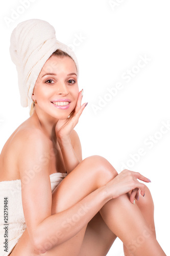 Portrait of a girl with pure and healthy glowing skin without makeup, using moisturizing creme after shower with the towel on her head and body, wellness and spa © Stavros